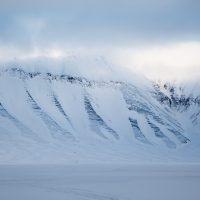 View of arctic valley and snowy mountains on Basecamp Explorer winter adventure in Spitsbergen.
