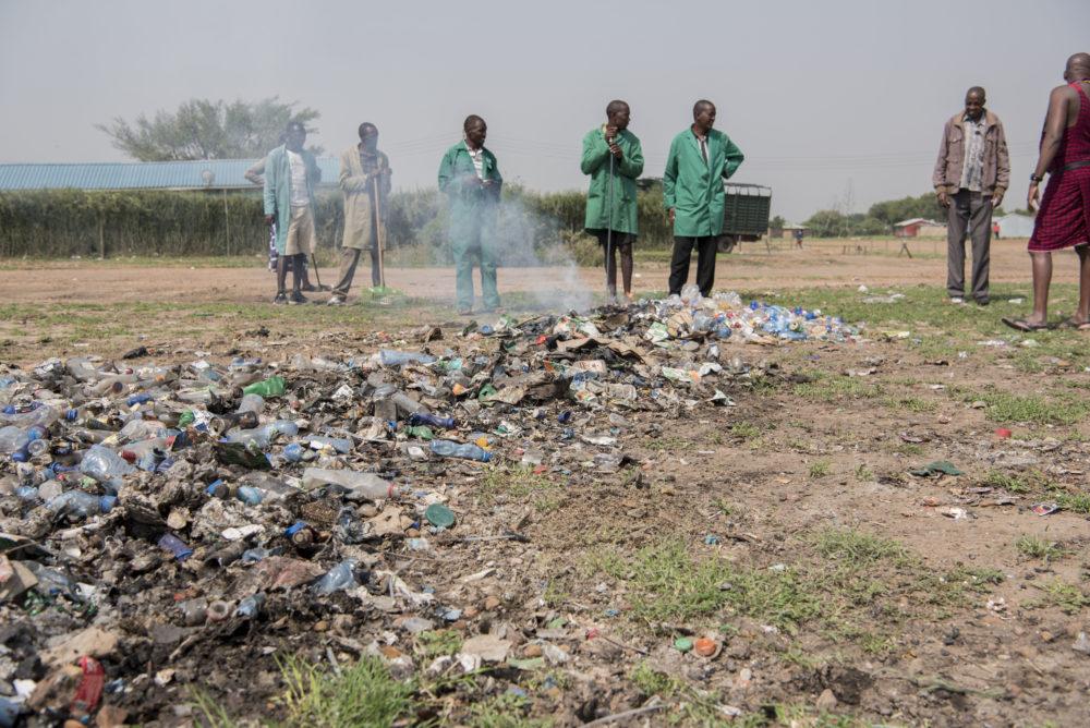 Locals cleaning up a field of plastic waste in Kenya.