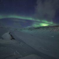 Northern lights over arctic valley while on Basecamp Explorer dogsledding adventure on Svalbard.